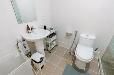 a white bathroom with a sink and a toilet at Cozy 2-Bedroom at South of Market SOMA BGC near SM Aura, Market! Market! & Bonifacio High Street in Manila