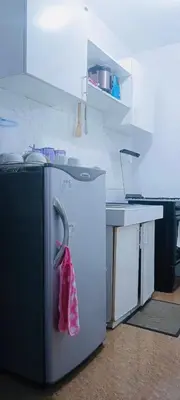 a kitchen with a refrigerator with a towel hanging on it at Avida sm sucat quest house condo hotel in Manila