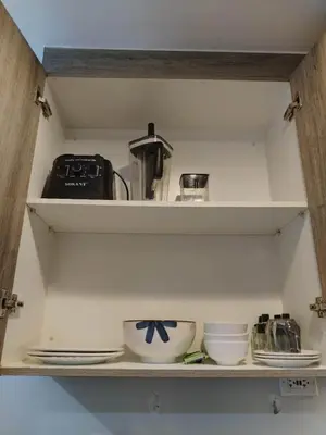 a shelf with bowls and other kitchen items on it at Coast Residence Sea View Balcony WiFi Netflix Near MOA 1524 in Manila