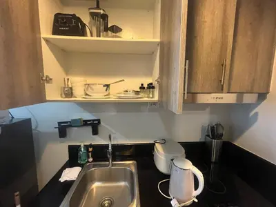 a kitchen counter with a sink and a cupboard at Coast Residence Sea View Balcony WiFi Netflix Near MOA 1524 in Manila