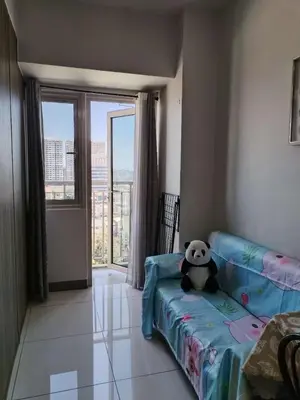 a panda bear sitting on a couch in a living room at Coast Residence Sea View Balcony WiFi Netflix Near MOA 1524 in Manila