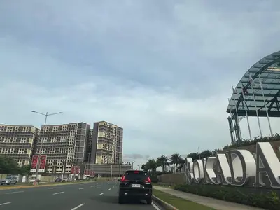 a car driving down a road in a city at Coast Residence Sea View Balcony WiFi Netflix Near MOA 1524 in Manila