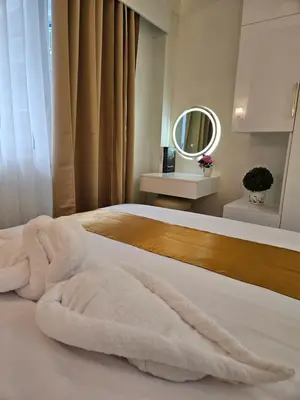 a bedroom with a white bed with a mirror at Luxury Condotel near MOA, NAIA in Manila