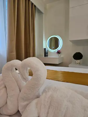 a pair of towel swans in a hotel room at Luxury Condotel near MOA, NAIA in Manila