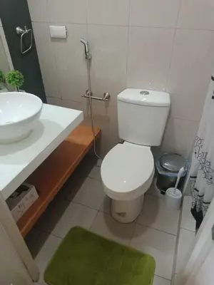 a bathroom with a white toilet and a sink at 1633 pool view 2br in Manila