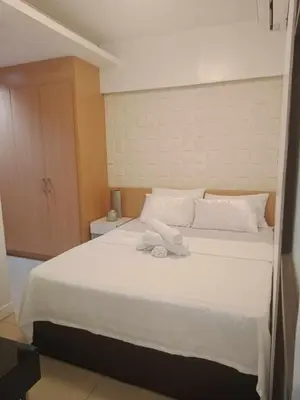 a bedroom with a white bed with towels on it at 1633 pool view 2br in Manila