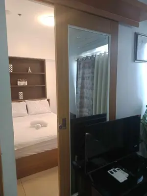 a room with a bedroom with a bed and a mirror at 1633 pool view 2br in Manila