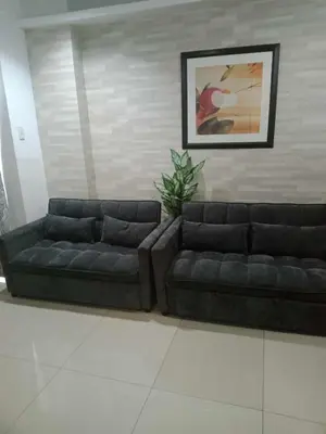 two black couches sitting in a living room at 1633 pool view 2br in Manila