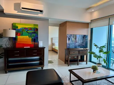 a living room with a tv and a table at BGC One Uptown Premium 2BR Suite with Balcony near Supermarket, Malls and Restaurants in Manila