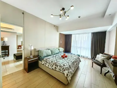 a large bedroom with a bed and a large mirror at BGC One Uptown Premium 2BR Suite with Balcony near Supermarket, Malls and Restaurants in Manila