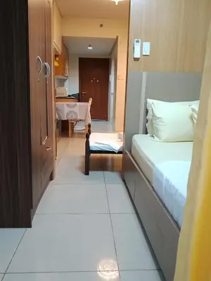a small room with a bed and a table at 232D pool view with big balcony in Manila