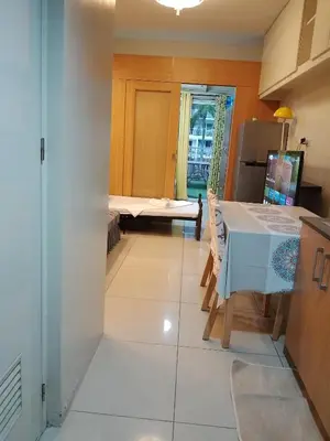 a view of a kitchen with a table and a room at 232D pool view with big balcony in Manila