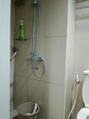 a shower in a bathroom with a toilet at 232D pool view with big balcony in Manila
