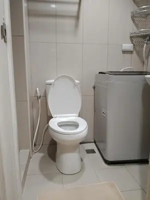 a bathroom with a white toilet and a sink at 232D pool view with big balcony in Manila