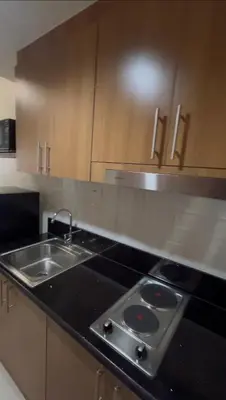 a kitchen with a sink and a stove top oven at Shore 3 Tower 3 1BD - MOA Complex in Manila