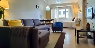 a living room with a couch and a table at Charming Modern Condo in BGC in Manila