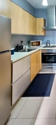 a kitchen with a sink and a stove at Charming Modern Condo in BGC in Manila