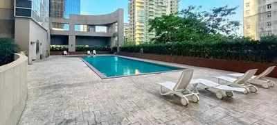 a swimming pool with two lounge chairs and a swimming pool at Charming Modern Condo in BGC in Manila