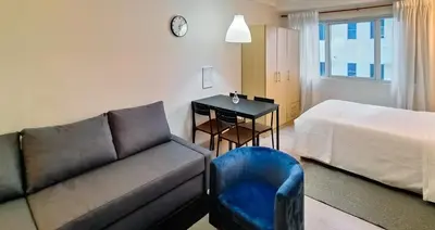 a living room with a couch and a bed and a table at Charming Modern Condo in BGC in Manila