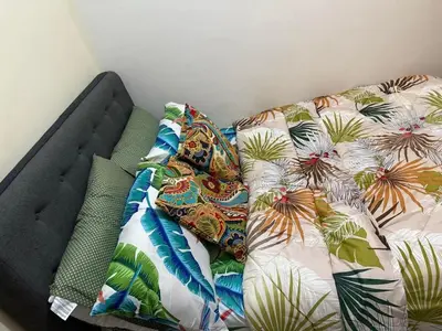 a bed with colorful pillows on top of it at Staycation with city lights in Manila