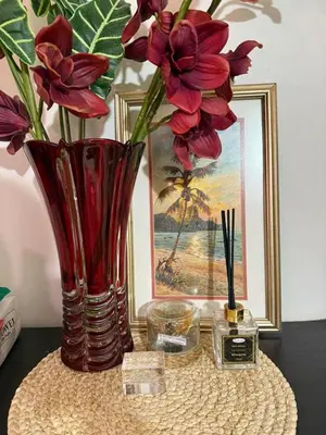 a table with two vases with flowers and a picture at Staycation with city lights in Manila