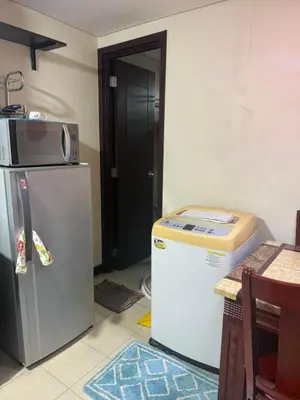 a kitchen with a microwave on top of a refrigerator at Staycation with city lights in Manila
