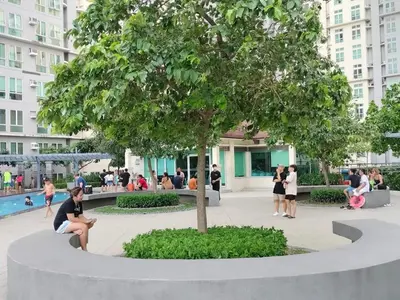 a woman sitting on a bench under a tree at Staycation with city lights in Manila