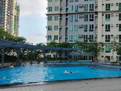 a large swimming pool with people in it with buildings at Staycation with city lights in Manila