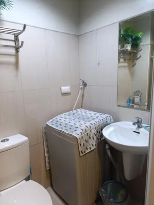 a bathroom with a toilet and a sink at Shell Residences - MOA in Manila