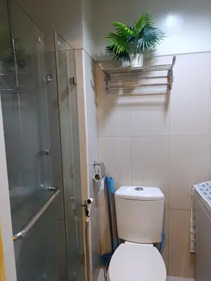 a bathroom with a toilet and a glass shower at Shell Residences - MOA in Manila