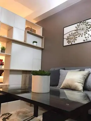 a living room with a blue couch and a table at Shore B 524 in Manila