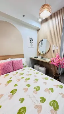 a bedroom with a large bed and a desk at Japanese Inspired Hotel at MOA in Manila