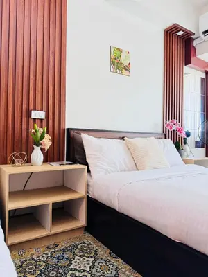 a bedroom with a bed and a table with a night stand at 2 Bed's Unit at PICC Near MOA in Manila