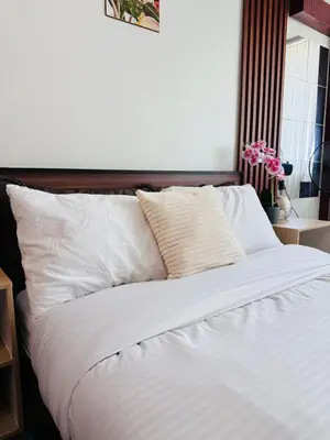 a large white bed with white sheets and pillows at 2 Bed's Unit at PICC Near MOA in Manila