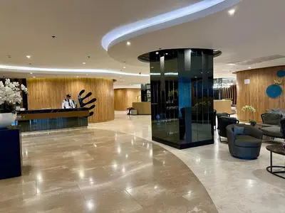 a lobby of a hotel with a man standing at a counter at Hotel like Condo at Pasay in Manila