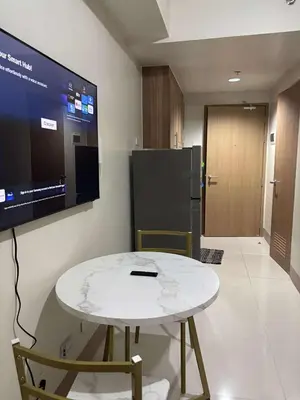 a white table and chairs in a room with a tv at Shore Residence Tower 1 Staycation in Manila