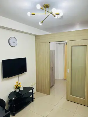a living room with a television and a sliding door at Apartment Rm# 839 B shore 1 in Manila