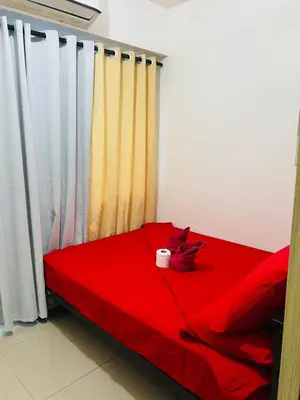 a red bed with a cup on top of it at Apartment Rm# 839 B shore 1 in Manila