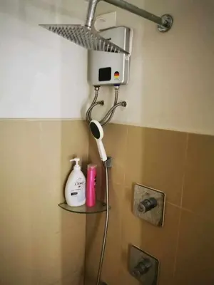 a shower head in the corner of a bathroom at Shore 3 tower 2 mall of Asia staycation in Manila