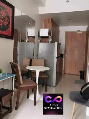 a room with a table and chairs and a kitchen at Shore 3 tower 2 mall of Asia staycation in Manila