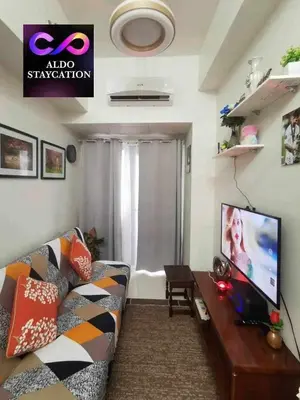 a living room with a couch and a tv at Shore 3 tower 2 mall of Asia staycation in Manila