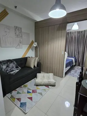 a living room with a couch and a bedroom at Mall of Asia - SMDC Shore in Manila