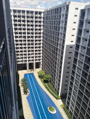 an overhead view of a swimming pool in front of a building at Mall of Asia - SMDC Shore in Manila