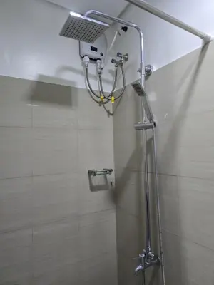 a shower with a shower head in a bathroom at Mall of Asia - SMDC Shore in Manila