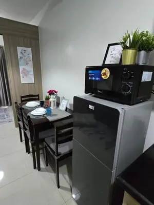 a kitchen and dining room with a table and a microwave at Mall of Asia - SMDC Shore in Manila