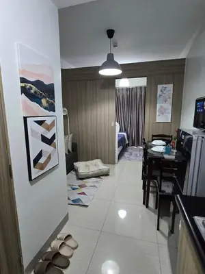 a living room with a kitchen and a dining room at Mall Of Asia - Shore Apartments in Manila