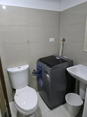 a small bathroom with a toilet and a sink at Mall Of Asia - Shore Apartments in Manila