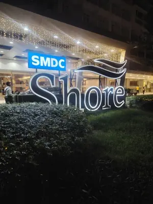 a sign in front of a store at night at Mall Of Asia - Shore Apartments in Manila