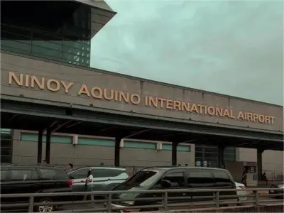 a building with cars parked in a parking lot at Mall Of Asia - Shore Apartments in Manila