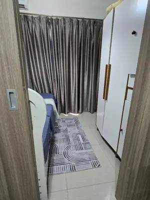 a small room with a bed and a curtain at Mall Of Asia - Shore2 Residences in Manila